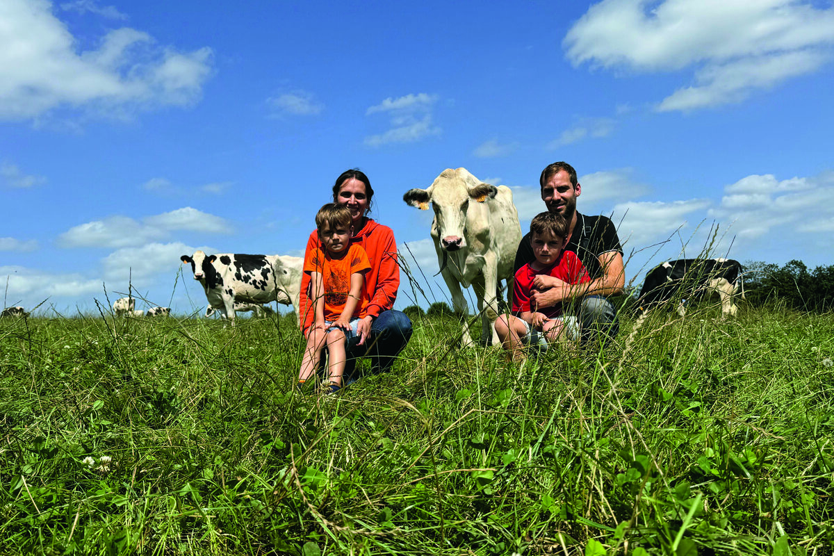 Un couple d'élevurs et leurs deux fils dans une prairie avec des vaches de race Holstein. - Illustration Un fort potentiel génétique à exprimer