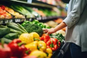 Un étal de légumes avec une personne en train de se servir
