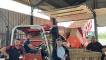 Trois hommes et une femme sous un hangar de réception et de tri de pommes de terre.s