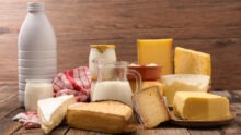 Un plateau de fromages et de produits laitiers posé sur une table en bois