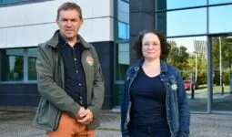 Un homme et une femme devant un bâtiment