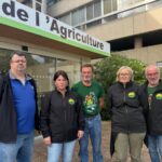 Trois hommes et deux femmes devant une Chambre d'agriculture.