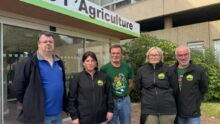Trois hommes et deux femmes devant une Chambre d'agriculture.