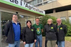 Trois hommes et deux femmes devant une Chambre d'agriculture.