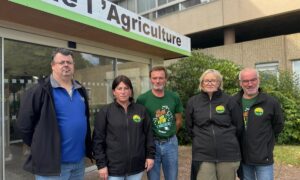 Trois hommes et deux femmes devant une Chambre d'agriculture.