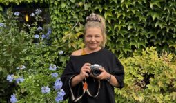 Une femme tenant un appareil photographique dans les mains.