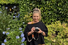 Une femme tenant un appareil photographique dans les mains.