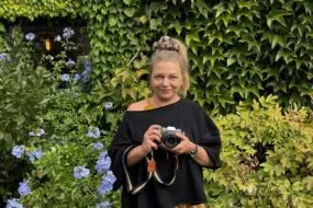 Une femme tenant un appareil photographique dans les mains.