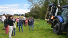 Groupe de personnes dans un champ devant un tracteur