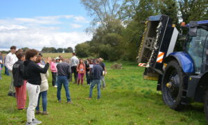 Groupe de personnes dans un champ devant un tracteur