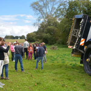 Groupe de personnes dans un champ devant un tracteur