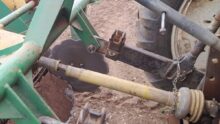 Une protection d'arbre à cardans d'une machine agricole endommagée.