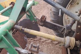 Une protection d'arbre à cardans d'une machine agricole endommagée.