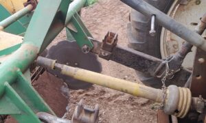 Une protection d'arbre à cardans d'une machine agricole endommagée.