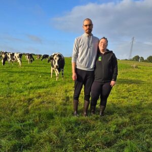 Un couple dans un champ avec un troupeau de vaches