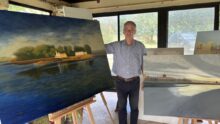 Une personne devant des tableaux