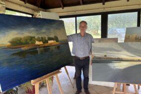 Une personne devant des tableaux