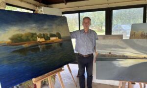Une personne devant des tableaux
