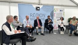 Un groupe de personnes assises sous un chapiteau lors d'un débat
