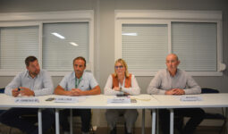 Quatre personnes assises à une table face à une assemblée