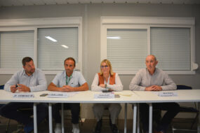 Quatre personnes assises à une table face à une assemblée