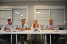 Quatre personnes assises à une table face à une assemblée