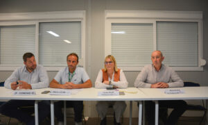 Quatre personnes assises à une table face à une assemblée