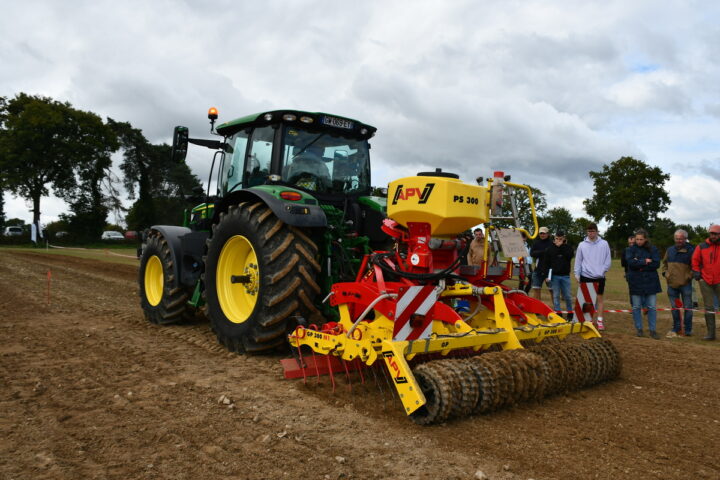 Un tracteur avec son semoir et des gens qui regardent