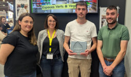 Un groupe de personne dont un tient un trophée dans ses mains