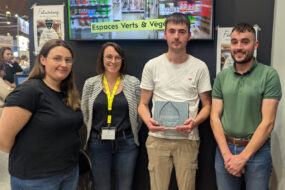 Un groupe de personne dont un tient un trophée dans ses mains
