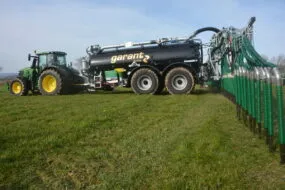 Un tracteur équipé d'une tonne à lisier Garant en train d'épandre dans un champ