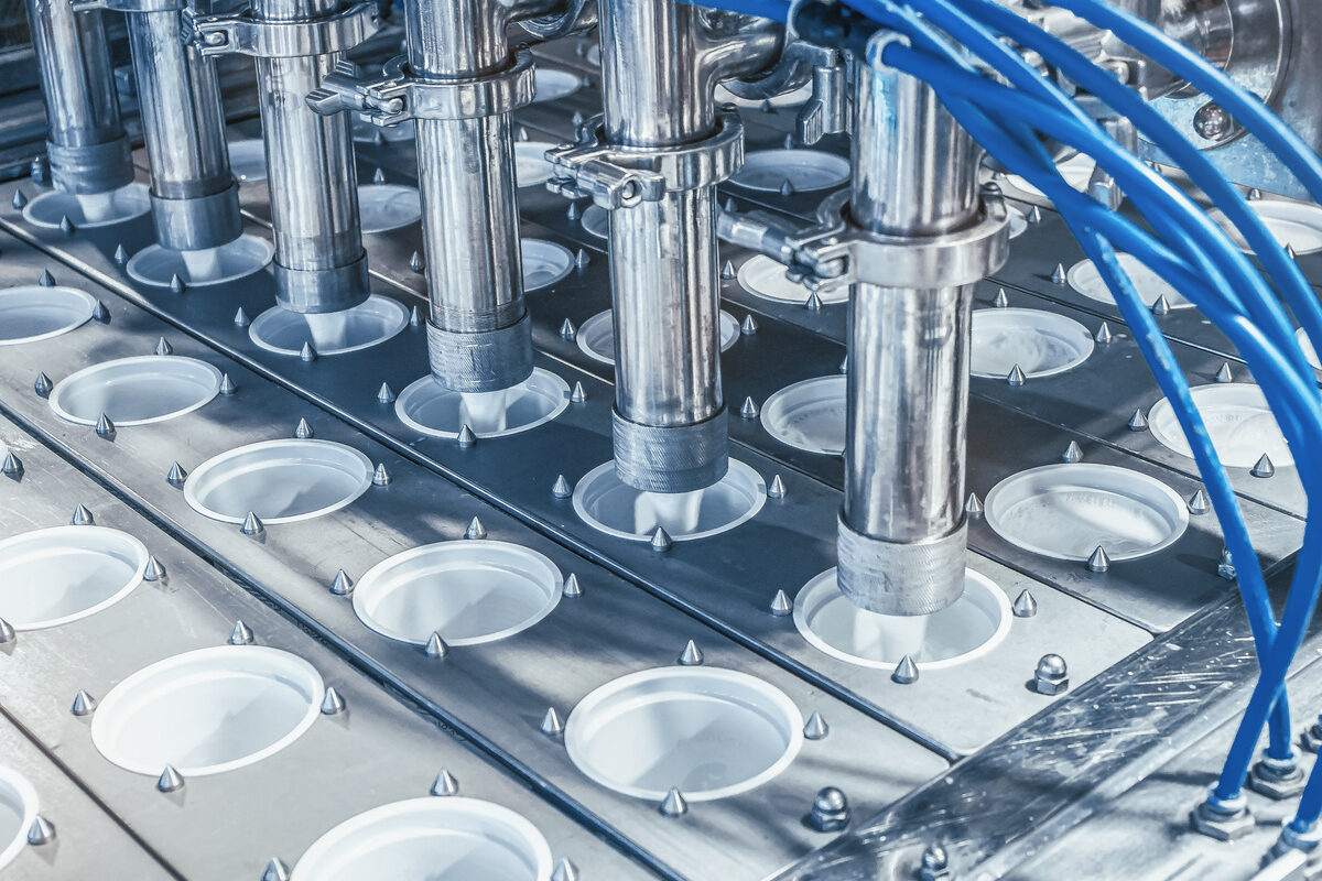 Gros plan sur une chaine industriel de conditionnement de produits laitiers - Illustration Europe, industrie, solidarité : Le lait, enjeu bien au-delà des fermes