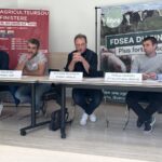 Des personnes à la tribune pendant une conférence de presse