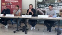 Des personnes à la tribune pendant une conférence de presse