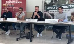 Des personnes à la tribune pendant une conférence de presse