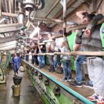 des gens et un éleveur dans un salle de traite