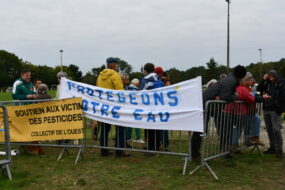 des gens derrière des banderoles lors d'un rassemblement