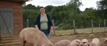Une femme dans un enclos avec une truie et ses porcelets