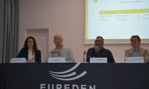 Quatre personnes à une tribine avec sur la nappe le logo Eureden