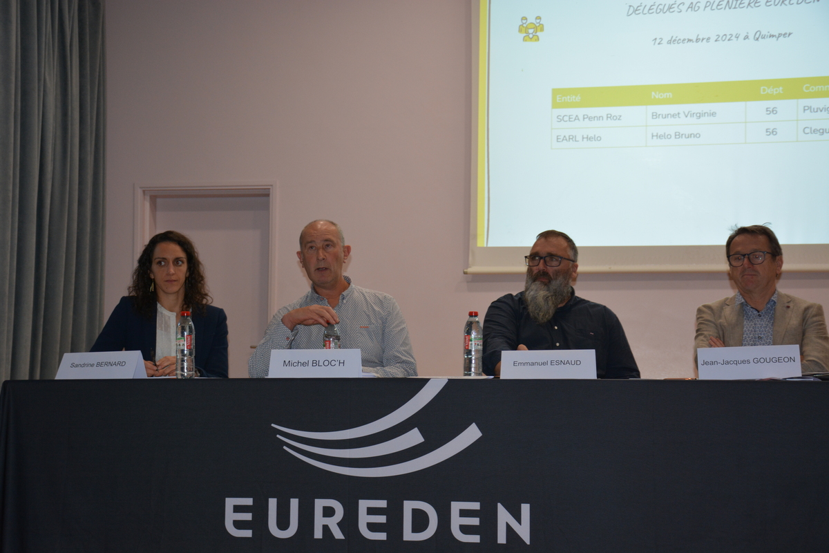 Quatre personnes à une tribine avec sur la nappe le logo Eureden - Illustration La défense d’un modèle coopératif solide