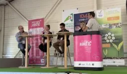 Trois personnes assises à des tables hautes et une autre derrière une banque d'accueil