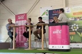 Trois personnes assises à des tables hautes et une autre derrière une banque d'accueil