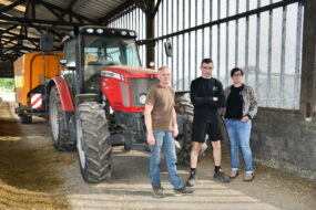 une femme et deux hommes devant un tracteur