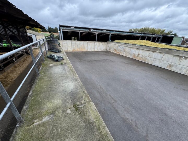 Aperçu d'un silo de maïs vide avec murs en blocs de bétons préfabriqués et sol couvert d'enrobé