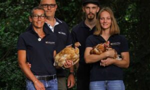 Deux hommes et deux femmes avec des poules dans les bras