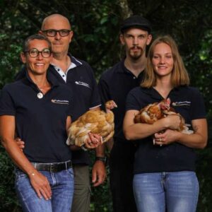 Deux hommes et deux femmes avec des poules dans les bras