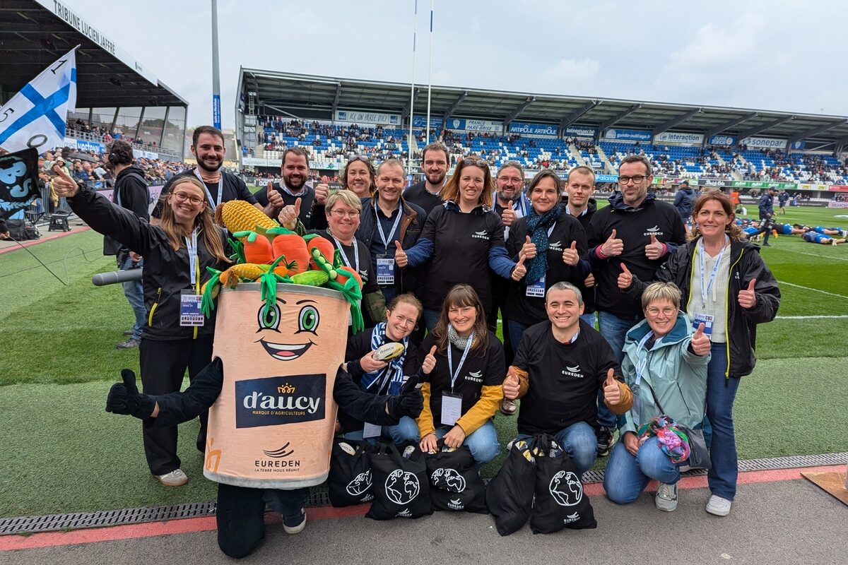 Un groupe de personne avec une mascotte d'Aucy dans un stade de rugby - Illustration Pourquoi une coopérative agricole s’engage-t-elle dans le sponsoring sportif ?