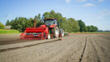Un tracteur au champ qui prépare la terre pour les semis de céréales
