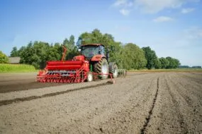 Un tracteur au champ qui prépare la terre pour les semis de céréales