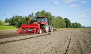 Un tracteur au champ qui prépare la terre pour les semis de céréales